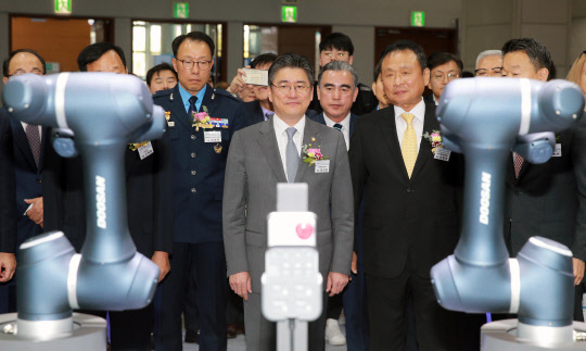 22일 경기도 고양 킨텍스 전시장에서 개막한 국내 최대 기계류 종합 전시회 '2019 한국산업대전'에서 정승일 산업통상자원부 차관(가운데) 등 관계자들이 로봇팔 제품 시연을 보고 있다. <산업통상자원부 제공>